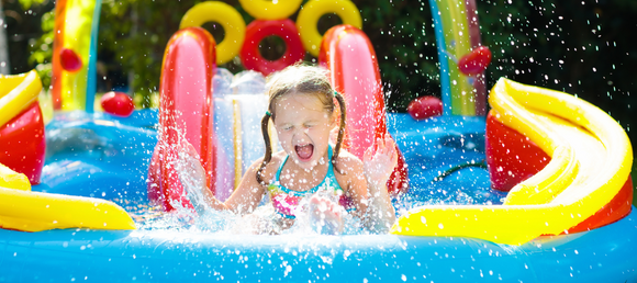 Girl splashing down inflatable water slide